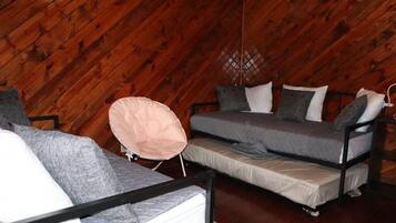 A loft-style room with a sloped ceiling, a bunk bed, and a single bed.