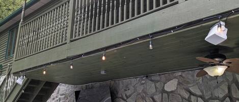 Un edificio con fachada de piedra, puerta verde y balcón con barandilla.