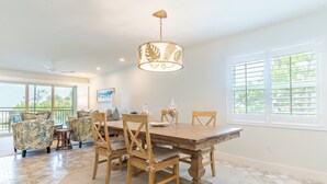 Un coin repas avec une table en bois, des chaises et un luminaire suspendu.