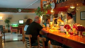 A bar area with wooden chairs and a counter. - Playamar (Tías)