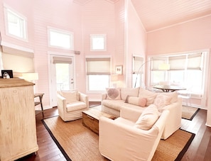 Relax in this stylish room with a large sofa, wooden sideboard, and a small table with a lamp.