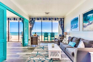 A living room with a view of the ocean, a balcony with chairs, and a coffee table. - WOW TRUE PENTHOUSE HONEYMOON JACUZZI CONDO/SWING/WINE/KING/30 FT BALCONY (Myrtle Beach)