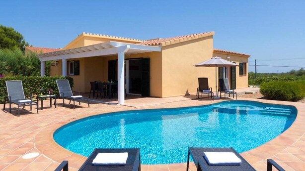 A swimming pool with lounge chairs and a covered patio area. - Villas Menorca Sur (Alayor)