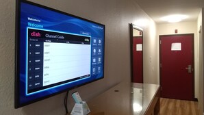 Una guía de canales digital en una pantalla fijada a la pared en un pasillo.