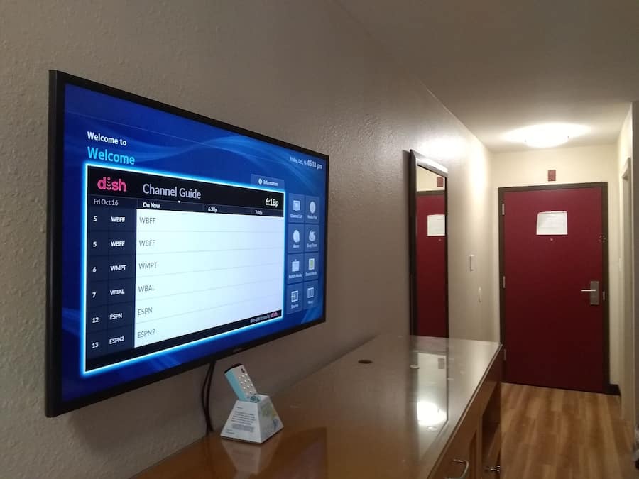 Guia de canals digital mostrada en un pantall fixat a la paret d'un passadís.
