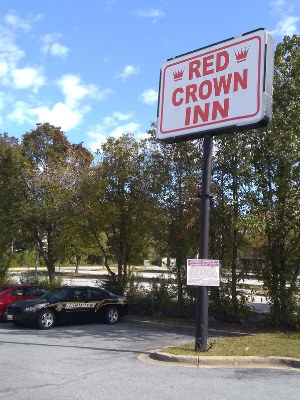 A sign for Red Crown Inn with a security car parked nearby. - Red Crown Inn (Laurel)