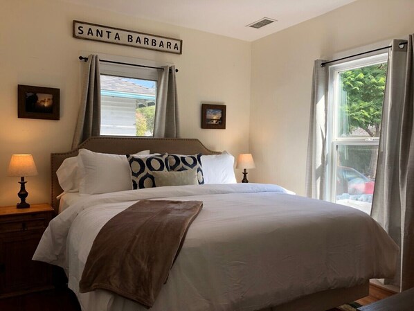 A neatly made bed with a brown throw blanket, two bedside lamps, and a sign above the bed that reads "SANTA BARBARA". - Darling Downtown, Walk Everywhere, Single Level, Quiet, AC, Pet Friendly (Santa Barbara)