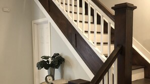 A staircase with dark wooden steps and white railings, leading to an upper floor.