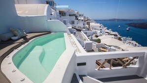 A rooftop pool area with a view of the sea and white buildings. - Chic Hotel Santorini (Santorini)