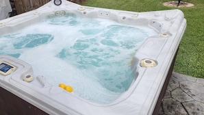 Un jacuzzi con panel de control, dos limones y un termómetro digital.