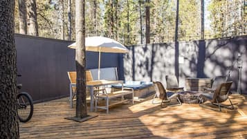 Relax on the outdoor deck with a hot tub, lounge chairs, and a bench, perfect for unwinding.