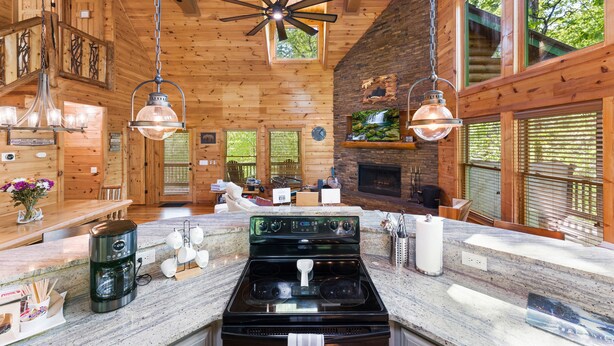 A spacious kitchen with a large stove, hanging lights, and wooden walls. - Luxury 3BD 3BA Cabin. Hot Tub,Pool Table,BBQ.Close to Helen, GA.Great for Groups (Cleveland)