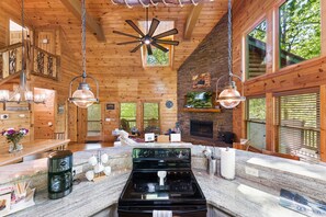 A spacious kitchen with a large stove, hanging lights, and wooden walls. - Luxury 3BD 3BA Cabin. Hot Tub,Pool Table,BBQ.Close to Helen, GA.Great for Groups (Cleveland)