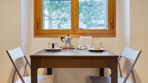 A table with a coffee pot, cups, and a menu card in front of a window. - GuestHost - Cozy apartment in Dorsoduro with GARDEN! (Venezia)