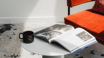 A modern room with a round table, a magazine, and a coffee cup.