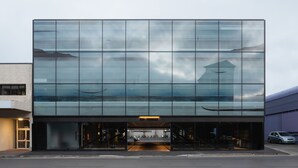 A modern building with a glass facade reflecting the sky and surroundings. - Ebb-Dunedin (Dunedin)