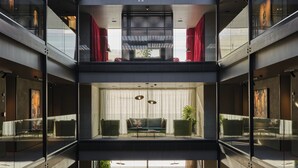 A modern interior with a central seating area, glass railings, and a view of the ocean. - Ebb-Dunedin (Dunedin)