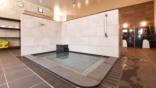 Une salle de bain moderne dotée d’un jacuzzi en verre, d’un lavabo et d’un espace douche.