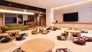 Un espace détente moderne, doté de sièges confortables, d’un téléviseur à écran plat et d’un distributeur automatique.
