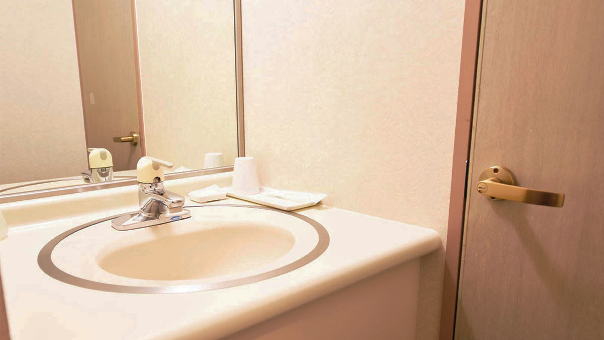 Pengering rambut, sandal, toilet dengan bidet elektronik, dan handuk