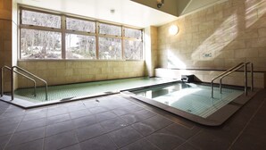 Une piscine avec deux couloirs, une fenêtre donnant sur les arbres et un mur avec un panneau.
