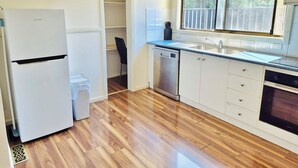Eine Küche mit Kühlschrank, Geschirrspüler und Backofen.