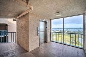 Enjoy a view of the water from this room, featuring a large window and a central elevator.