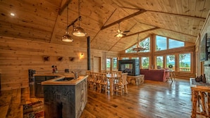 A spacious log cabin interior with a large dining area, kitchen, and a fireplace. - Serenity Peak | Mountain View | Close To Town | Paved | Dog Friendly (Blue Ridge)