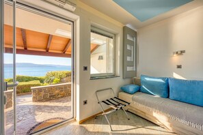 Una sala de estar moderna con un sofá, una mesita y vista al mar.