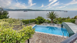 Ein Pool mit Blick auf das Meer und Schiffe in der Ferne.
