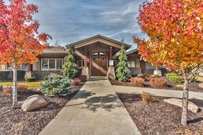 A two-story house with a stone facade, a front porch, and a driveway leading to the entrance.