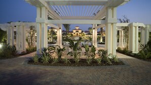 A white pergola structure with a brick pathway leading to a building with a dome. - Amazing Orange Lake Resort - 2 BR Luxury Condo.  Near Disney  (Kissimmee)