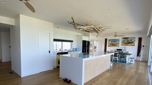 Una cocina amplia con isla central, piso de madera y ventilador de techo.