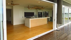 Una cocina moderna con una isla central, un comedor y vistas al exterior.