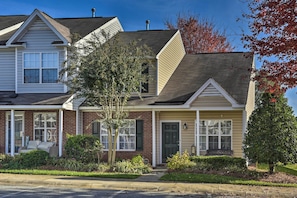 Stunning two-story home with a charming facade, featuring a covered porch and beautifully maintained gardens.