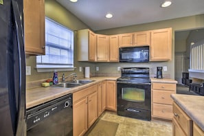 Enjoy cooking in this kitchen with a stove, microwave, and dishwasher, plus a convenient dish soap dispenser and window with blinds.