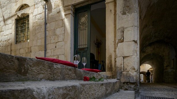 A stone staircase leading to a building with a green door and a window with bars. - Apartment Klara (Dubrovnik)