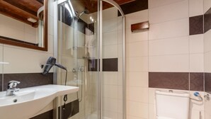 A bathroom with a glass-enclosed shower, a sink, and a toilet. - Apartment Klara (Dubrovnik)