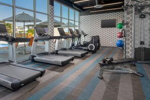 A gym with treadmills, elliptical machines, and weightlifting equipment. - Aloft by Marriott Lubbock (Lubbock)