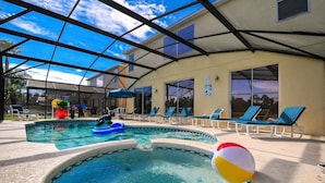 A covered outdoor swimming pool with lounge chairs and a beach ball. - The Lake House! 7Br 4.5ba with private pool! (Kissimmee)