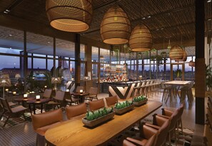 A spacious restaurant with high ceilings, large windows, and a bar area.