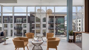 A modern interior with large windows, contemporary furniture, and a view of surrounding buildings. - Element by Marriott Tampa Midtown (Tampa)