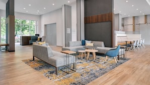 A spacious lobby with modern furniture, a large window, and a visible kitchen area. - TownePlace Suites by Marriott Columbus Dublin (Dublin)