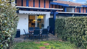 A two-story building with a patio area featuring a table and chairs. - T2 Apartment mezzanine with terrace and pets allowed (Soustons)
