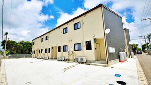 Um hotel de vários andares com fachada plana, unidades de ar condicionado e antenas parabólicas.