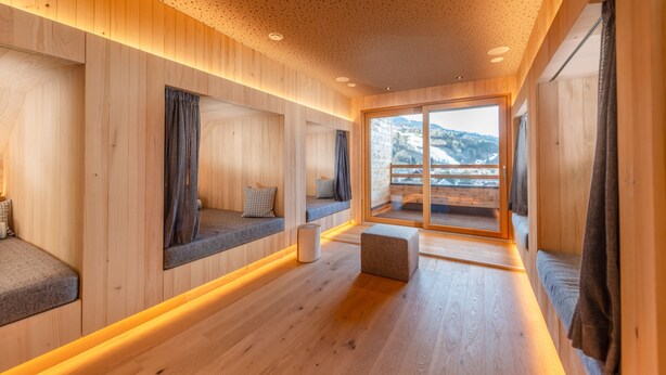 A wooden interior with built-in seating, a large window, and a view of the outdoors. - Stadtvilla Schladming Boutiquehotel (Schladming)