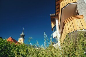 En bygning med balkon og et tårn i baggrunden.