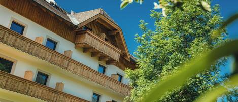 Un edificio de varios pisos con balcones de madera y un cielo azul despejado.