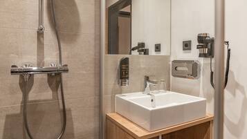 A modern bathroom with a shower, a sink, and a mirror.