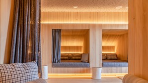 A modern interior with wooden paneling, a sofa, and a bench with cushions. - Stadtvilla Schladming Boutiquehotel (Schladming)